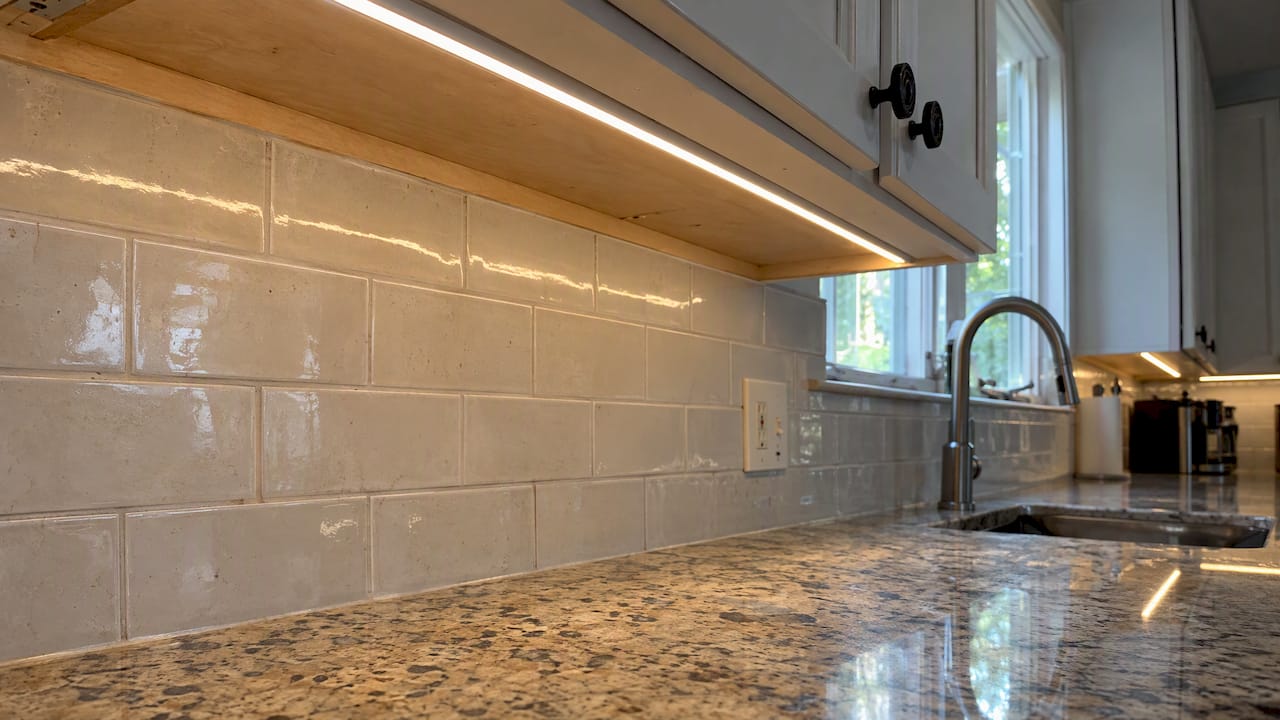 Under-cabinet strip lighting illuminates a kitchen counter